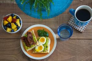a plate of food with a sandwich and a bowl of fruit at The Serene House Bed & Breakfast in Luquillo