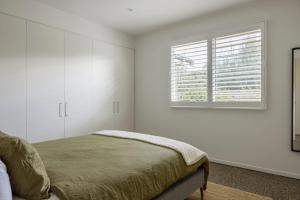 1 dormitorio con cama y ventana en Marittimo, en Point Lonsdale