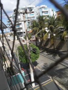 - une vue sur une rue bordée de palmiers et de bâtiments dans l'établissement 50 m da Praia do Forte em Cabo Frio 2 quartos cozinha garagem wi fi para ate 8 pessoas!, à Cabo Frio