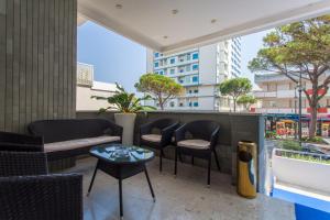 - un balcon avec des chaises et des tables dans un bâtiment dans l'établissement Hotel Esplanade, à Cesenatico