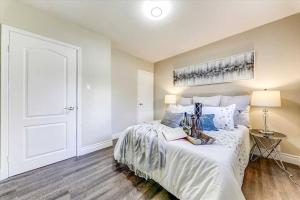 1 dormitorio con cama blanca y puerta blanca en Luxurious private home for perfect getaway, en Oshawa