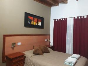 Un dormitorio con una cama y una cortina roja. en EL OASIS Habitaciones, en Córdoba 19 fotos más