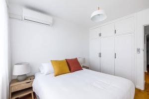 a white bedroom with a white bed and white cabinets at Edge of Elwood - Unwind in Style by St Kilda Beach in Melbourne