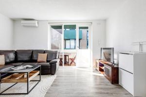 a living room with a couch and a tv at Bridport Rest - A Relaxed Albert Park Abode in Melbourne