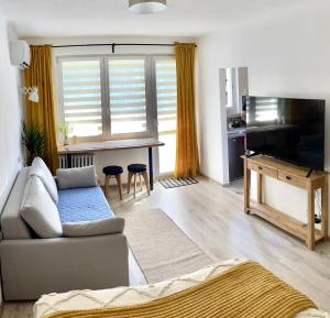 a living room with a couch and a television at Studio 2 Apartment in Ełk