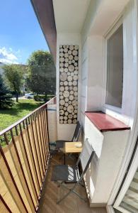 a balcony with a chair and a desk and a window at Studio 2 Apartment in Ełk