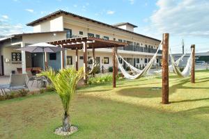 a resort with a hammock and a building at Flats Charme do Cerrado in Pirenópolis