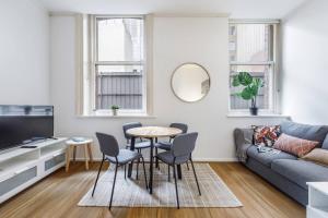 a living room with a table and chairs and a couch at Deste Studio - A Modern Boutique Lifestyle Suite in Melbourne