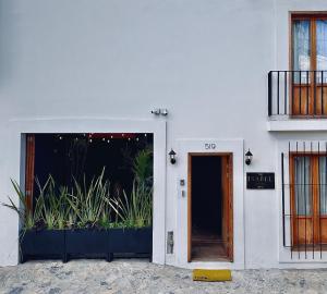 un edificio bianco con una porta e piante di The Isabel Hotel a Sombrerete