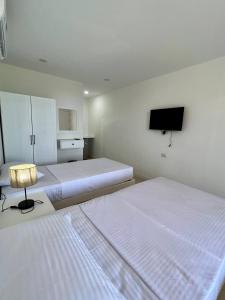1 dormitorio con 2 camas y TV de pantalla plana en Serafy City Center Hostel and Pool for Foreigners Adults Only en Hurghada