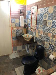 La salle de bains est pourvue de toilettes, d'un lavabo et d'un miroir. dans l'établissement Gopal Ecolodge (ecofinca), à Barbosa