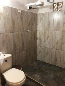 La salle de bains est pourvue de toilettes et d'un mur carrelé. dans l'établissement Gopal Ecolodge (ecofinca), à Barbosa