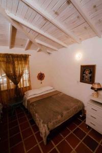 - une chambre avec un lit et un plafond en bois dans l'établissement Gopal Ecolodge (ecofinca), à Barbosa