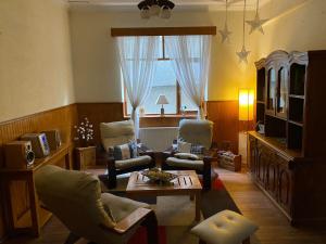 プンタ・アレナスにあるCHALET CHAPITAL Punta Arenasのリビングルーム(椅子、テーブル付)、窓が備わります。