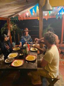 Un groupe de personnes assises à une table et mangeant de la nourriture dans l'établissement Gopal Ecolodge (ecofinca), à Barbosa