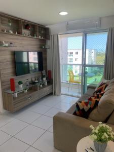 a living room with a couch and a flat screen tv at Palm Village - Porto de Galinhas/Cupe/Muro Alto in Porto De Galinhas