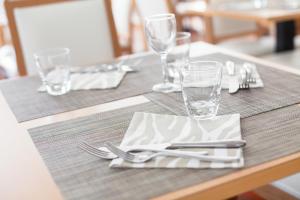 einen Tisch mit Besteck auf einem Holztisch in der Unterkunft Hotel Esplanade in Cesenatico + 26 Fotos