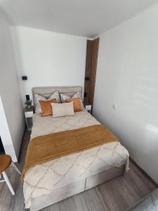 a bedroom with a large bed with orange pillows at Studio 2 Apartment in Ełk