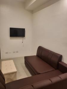 sala de estar con sofá y TV de pantalla plana en Spacious Minimalist Studio at Matina Enclaves en Davao