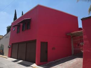 un edificio rojo con dos puertas de garaje en Suite Palma, Experiencia Única, Nómadas Digitales, Home Office o Vacacional, en Tepotzotlán