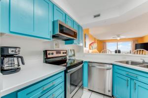 una cocina con armarios azules y fregadero en Updated Oceanfront Condo! Come Relax by the Sea! en Ormond Beach