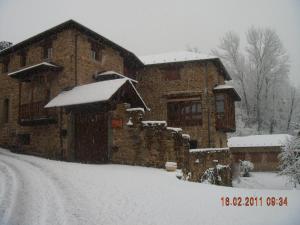 una casa cubierta de nieve delante en Posada Real El Sendero del Agua, en Trefacio