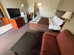 a hotel room with a bed and a flat screen tv at Red Carpet Inn Oxford in Oxford