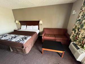 a hotel room with a bed and a couch at Red Carpet Inn Oxford in Oxford