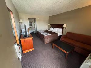 a hotel room with a bed and a couch at Red Carpet Inn Oxford in Oxford