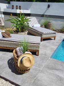 - une terrasse avec 2 bancs et un chapeau à côté de la piscine dans l'établissement Le'Oasis Villa, à Juncos