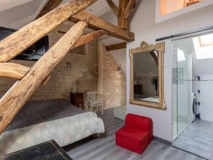 1 dormitorio con cama, espejo y taburete rojo en Cottage with independent studio in Molesme, en Villiers-les-Moines