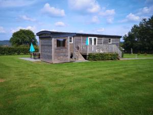een kleine hut met een terras in een grasveld bij Quaint Mobile Home with Sauna in Vielsalm in Vielsalm