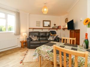 uma sala de estar com uma mesa e um sofá de couro em Stagsholt Lodge em Washfield