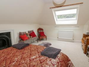 a bedroom with a bed and a fireplace and a window at Rose Cottage in Melrose