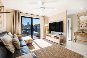 sala de estar con sofá y TV en Alkira - Pet Friendly - 4 Mins Walk to Beach, en Culburra Beach