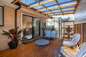 a patio with chairs and a table on a deck at Alkira - Pet Friendly - 4 Mins Walk to Beach in Culburra Beach