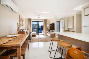 een keuken en een woonkamer met een tafel en stoelen bij Alkira - Pet Friendly - 4 Mins Walk to Beach in Culburra Beach