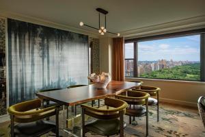 a dining room with a table and chairs and a large window at JW Marriott Essex House New York in New York
