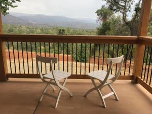2 sillas sentadas en un porche con vistas en Morning Star Vista near Yosemite - countryside with mountain views, en Mariposa
