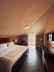 um quarto com uma cama grande e uma televisão de ecrã plano em La Estancia em San Cristóbal de Las Casas