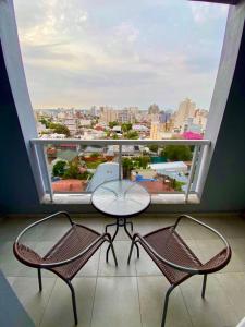 a balcony with a table and two chairs and a large window at Capibara 2- alquiler temporario. in Corrientes