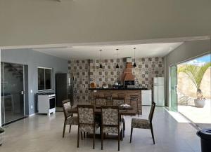 une cuisine et une salle à manger avec une table et des chaises dans l'établissement Chácara Por do Sol, à Serra Negra