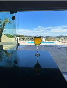 un verre de vin assis au-dessus d'une table dans l'établissement Chácara Por do Sol, à Serra Negra