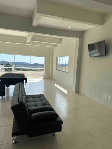 - un salon avec un canapé et un billard dans l'établissement Chácara Por do Sol, à Serra Negra