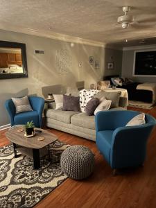 sala de estar con sofá, 2 sillas y mesa en The Bear’s Den en Charleston