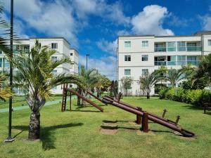 einen Spielplatz in einem Park vor einem Gebäude in der Unterkunft Palm Village Acqua Porto de Galinhas por Brevelar in Porto De Galinhas