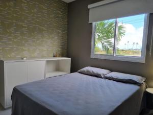 ein Schlafzimmer mit großem Bett und Fenster in der Unterkunft Palm Village Acqua Porto de Galinhas por Brevelar in Porto De Galinhas + 31 Fotos