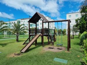ein Spielplatz in einem Park mit einer Schaukel in der Unterkunft Palm Village Acqua Porto de Galinhas por Brevelar in Porto De Galinhas