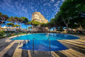 ein Pool mit einem Gebäude im Hintergrund in der Unterkunft Modern studio apartment with sea views 5 min from the beach in Sitio de Calahonda