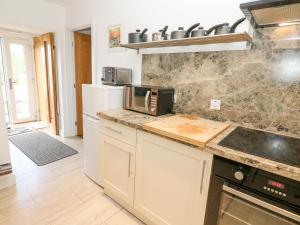 a kitchen with white cabinets and a counter top at Skovhaven in Catton